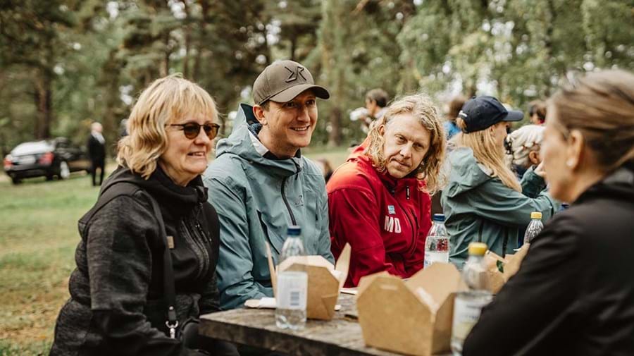 Representanter från RevolutionRace och Svenska Livräddningssällskap m.fl. äter lunch och samtalar vid stoppet i Gula slingans naturreservat.